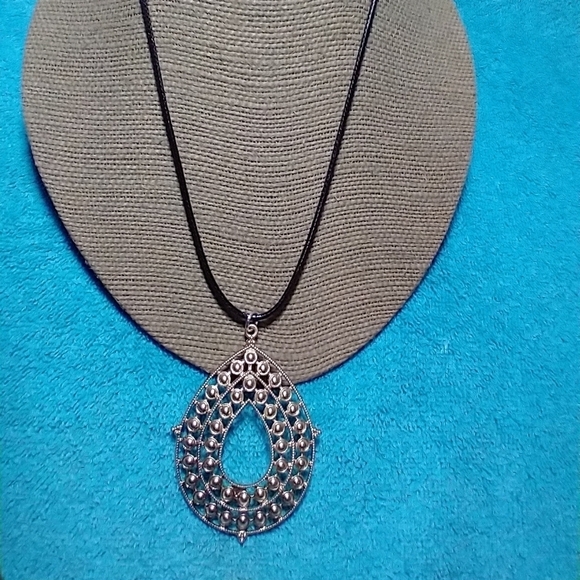 Goldtone intricate design teardrop necklace with black cord - Picture 2 of 4